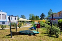 Voile d'ombrage triangulaire sur une aire de jeux protégeant le bac à sable du soleil et des UV