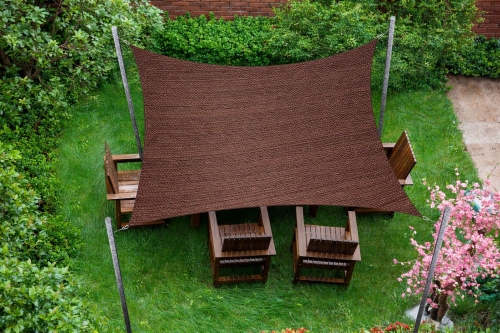 Voile d'ombrage carrée marron en HDPE sur mesure tendue au-dessus de meubles de jardin en bois