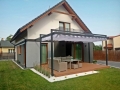 Rulou roman Premium impermeabil pentru terasă cu dimensiuni 2,5x4 m montat pe o pergolă modernă lângă casă