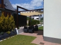 Jaluzea romană Premium bej pentru terasă montată pe o pergolă din lemn deasupra unui set de mobilier de grădină