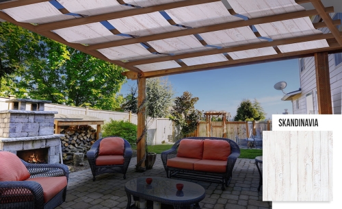 Bande de pavillon Skandinavia imperméable avec impression bois installée sur une pergola en bois au-dessus d'une terrasse avec meubles de salon