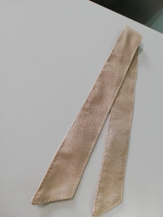 Béžová stuha na uviazanie záhradného závesu z odolného materiálu na svetlom pozadí