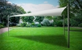 Pânză de umbrire triunghiulară albă montată pe stâlpi într-o grădină verde mare care creează o zonă de umbră