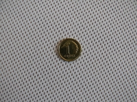 Une pièce de 1 grosz posée sur le tissu blanc d'un store romain avec une fine perforation mesh à pois