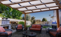 Voile d'ombrage de gazebo blanche sur une pergola en bois avec vue sur la terrasse avec meubles de jardin et cheminée