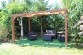 Beige solskydd i HDPE för lusthus monterat på en träpergola i en trädgård med loungemöbler
