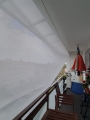 Voile d'ombrage rectangulaire blanche 3,2x2,5 m installée sur un balcon protégeant du soleil et offrant de l'ombre
