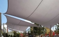 Toldo vela cuadrado impermeable 4x4 m gris sobre una terraza y cafetería de jardín