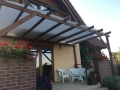 Voile d'ombrage rectangulaire blanche 3,2x2,5 m montée sur une pergola en bois au-dessus d'une terrasse avec meubles de jardin