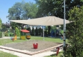 Voile d'ombrage de jardin beige 3,2x2,5 m au-dessus d'un bac à sable sur une aire de jeux pour l'ombre