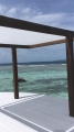 Voile d'ombrage de jardin blanche 3,2x2,5 m montée sur une pergola en bois au bord de la mer