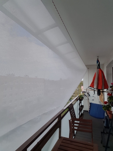 Biela obdĺžniková slnečná clona namontovaná na balkóne pre ochranu pred slncom a súkromie