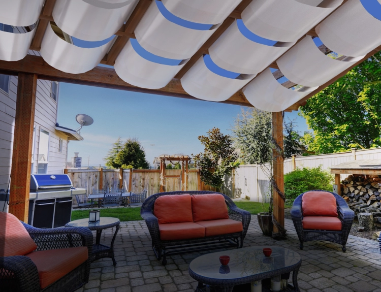Bande d'ombrage blanche pour pavillon montée sur une pergola en bois au-dessus d'une terrasse avec mobilier de jardin