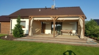 Vodotesný záhradný záves na mieru namontovaný na drevenom altánku pri terase rodinného domu